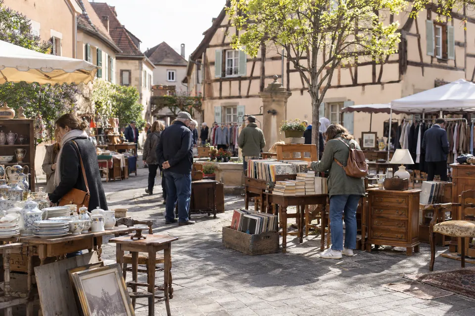 Brocante illustrative devant des façades pastel et à colombages