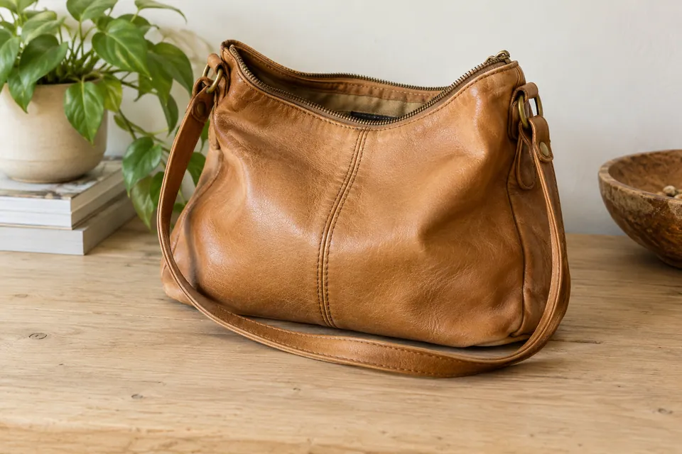 Sac en cuir brun avec sa bandoulière et des marques d’usage
