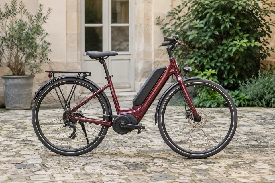 Vélo électrique bordeaux dans une cour pavée
